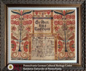 A framed document which features red, yellow, and blue leaf, flower, and bird motifs. In the center of the document are two bordered boxes with information on Moses Dunckel in German script.