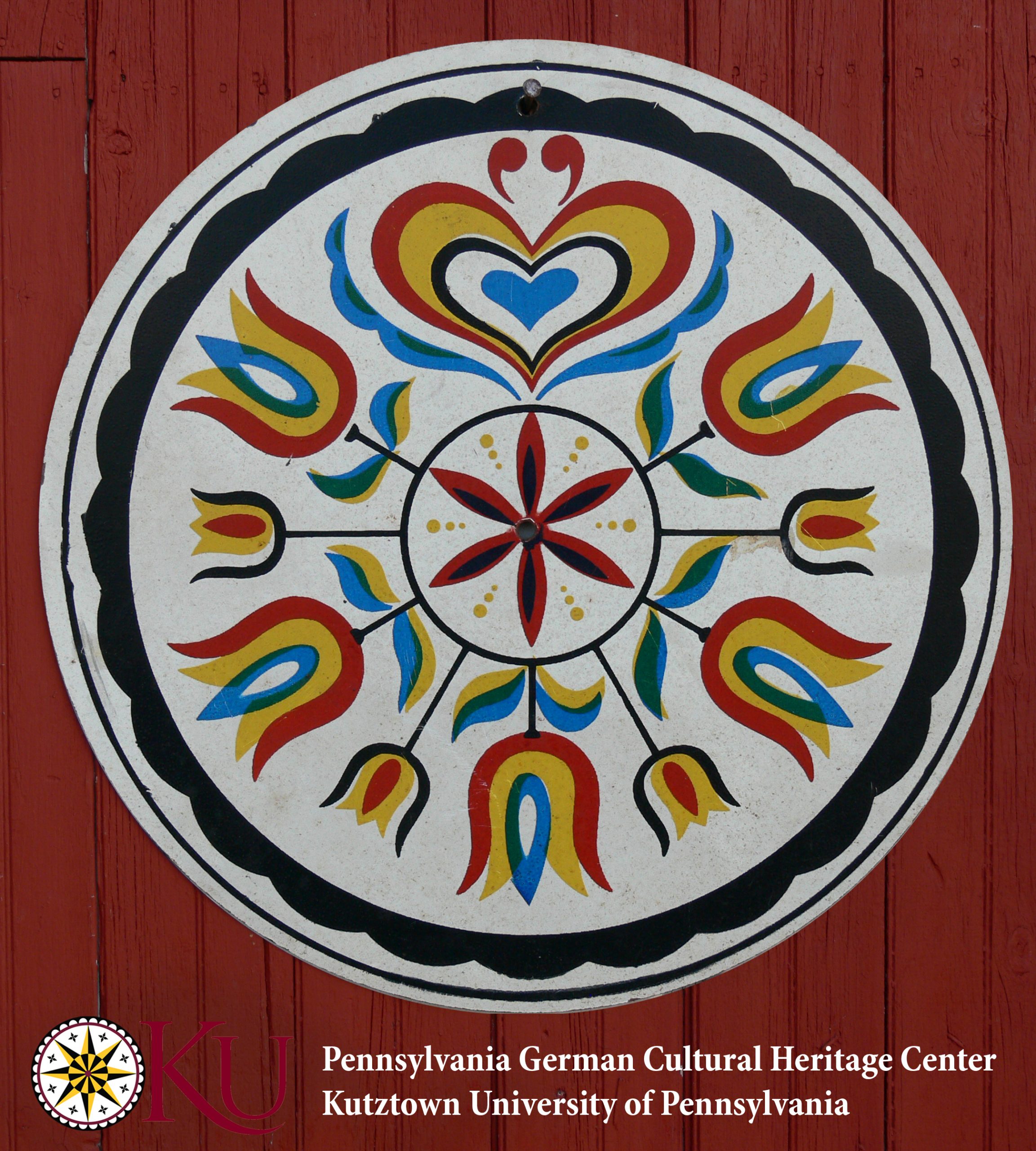 A center 6-pointed rosette in red and black is surrounded by nine stylized tulips emanating from the center. A stylized heart is at the top in the center. All of these designs are in red, yellow, blue, green, and black. The entire sign is encompassed by a black scalloped border.